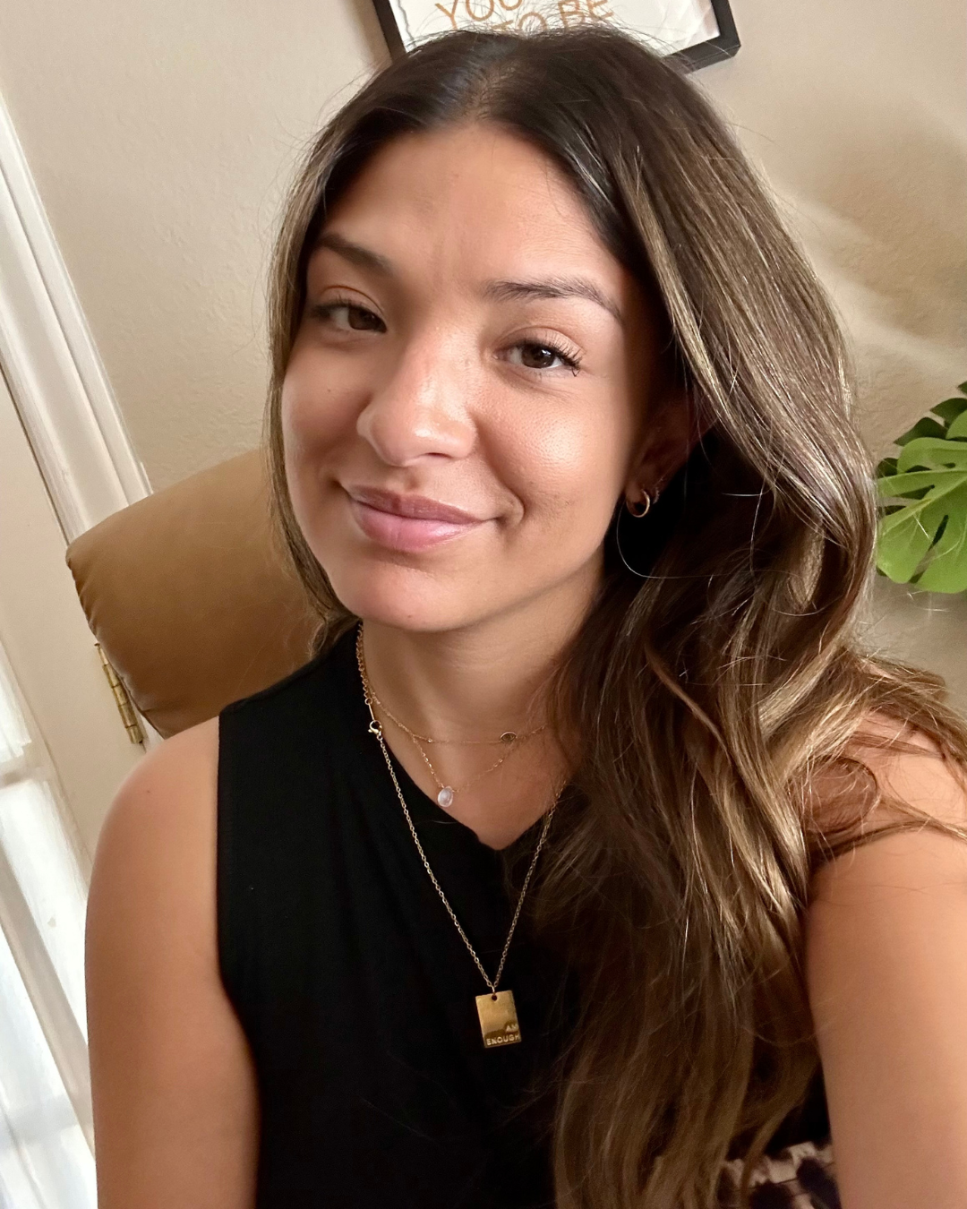 Latina woman smiling softly while wearing the I Am Enough Necklace--a daily affirmation piece crafted for women who know their worth and need a gentle reminder when life gets loud.