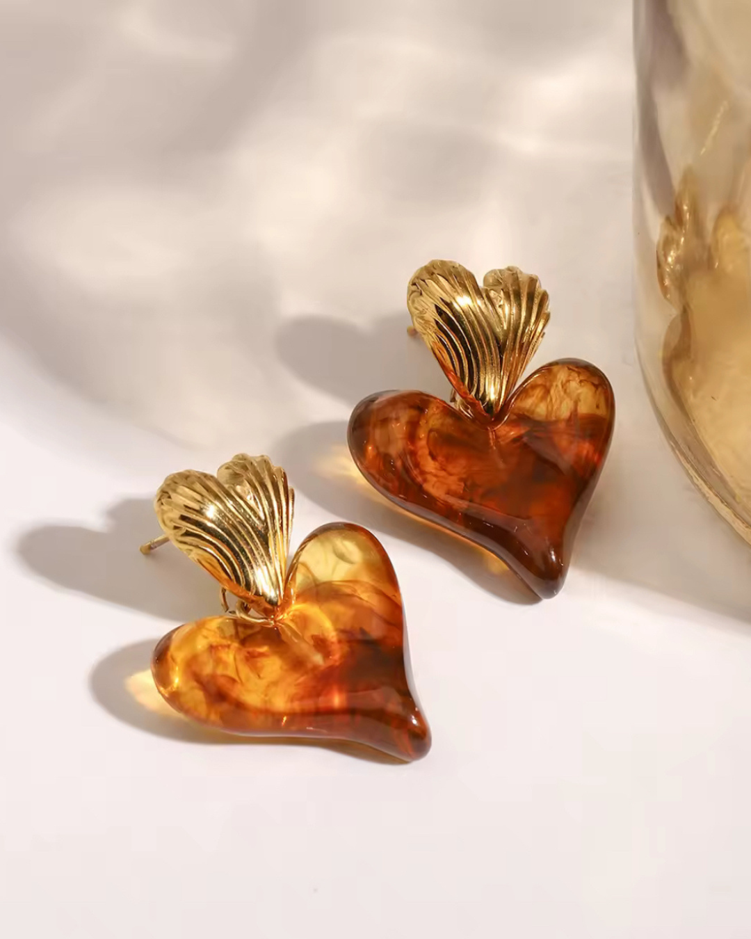 Golden heart studs with amber resin drops forming the Love on Top Earrings, a romantic symbol of love and devotion that adds warmth and meaning to every look.