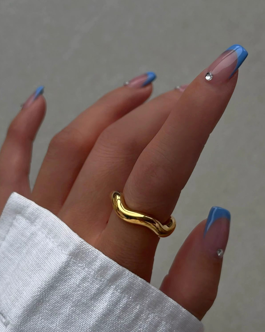 Lifestyle photo of the Wave Runner Ring in polished gold. A sculptural wavy band designed for women who love modern luxury and bold everyday style.