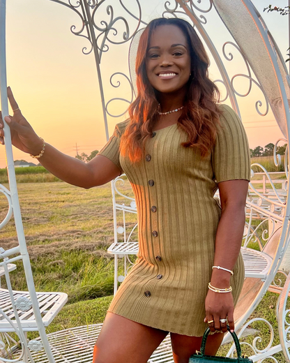 CEO of I Am Luxury Accessories Boutique smiling at sunset wearing the In Full Bloom Bracelet stacked with gold jewelry, paired with the matching In Full Bloom Necklace, styled with a ribbed dress and handbag for an elegant outdoor look.