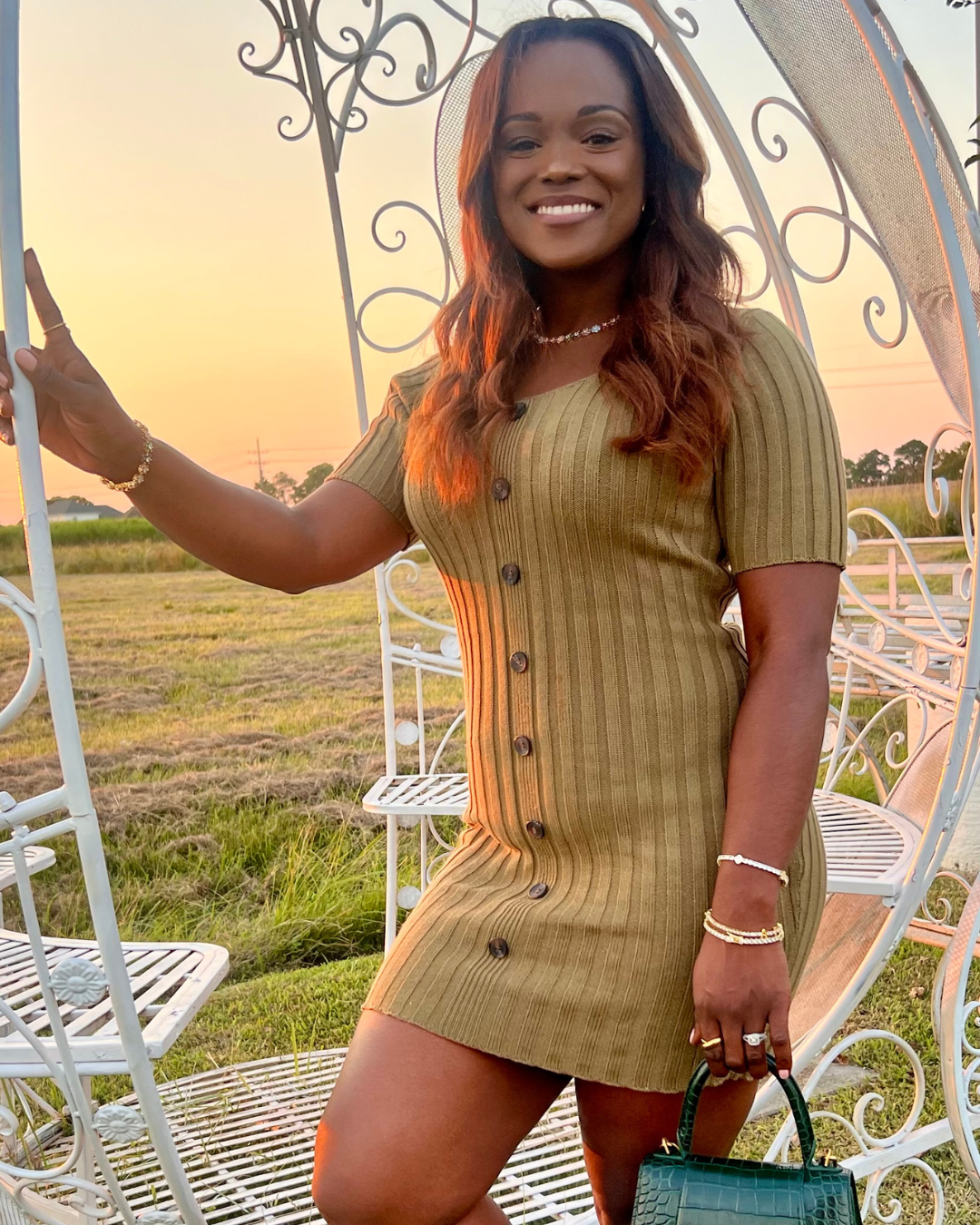 Model smiling at sunset in a ribbed dress, styled with the In Full Bloom Necklace featuring multicolor CZ floral clusters, paired with stacked gold bracelets and rings for an elegant outdoor look.