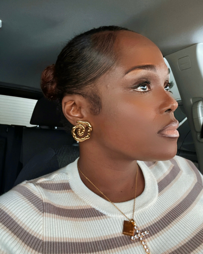 Woman leaving brunch wearing Twist of Faith Earrings in gold with a striped top, layered I Am Enough Necklace, and Faithfully Fine Cross Necklace — a look that transitions effortlessly from brunch to church.