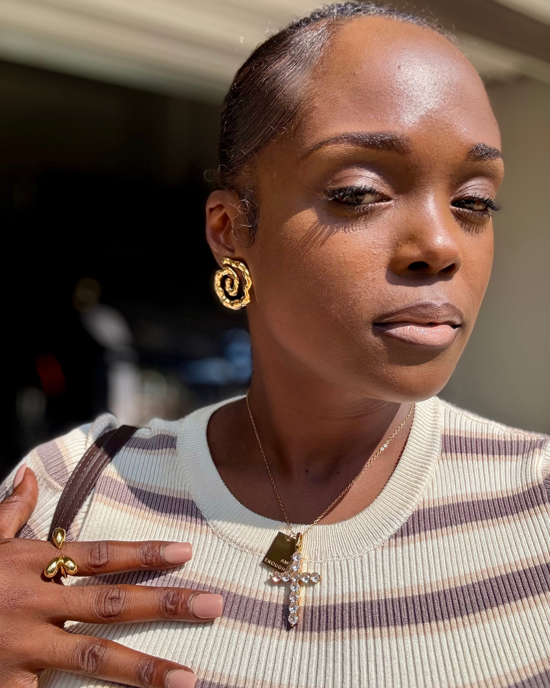 Close-up of a woman wearing the Twist of Faith Earrings in gold, paired with the I Am Enough Necklace, Faithfully Fine Cross Necklace, and the Modern Muse Ring in gold — all from I Am Luxury Accessories Boutique.