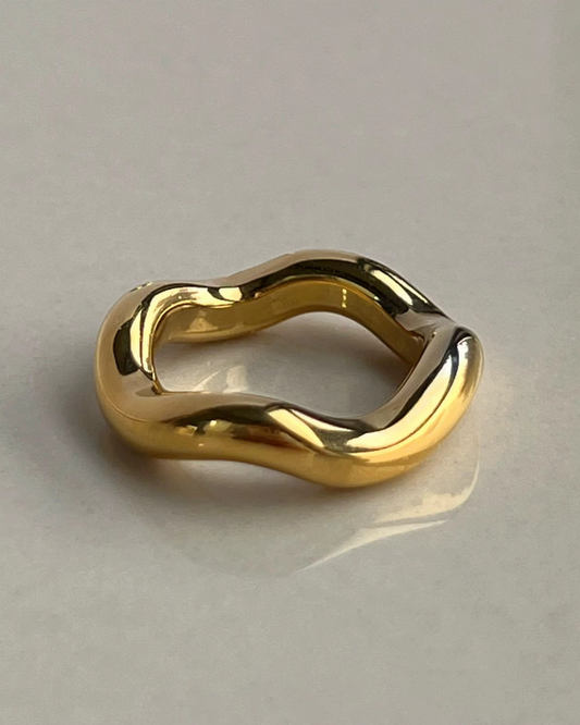 The Wave Runner Ring in polished gold with a fluid sculptural band design. A modern luxury statement ring for women that blends bold style with elegance. 