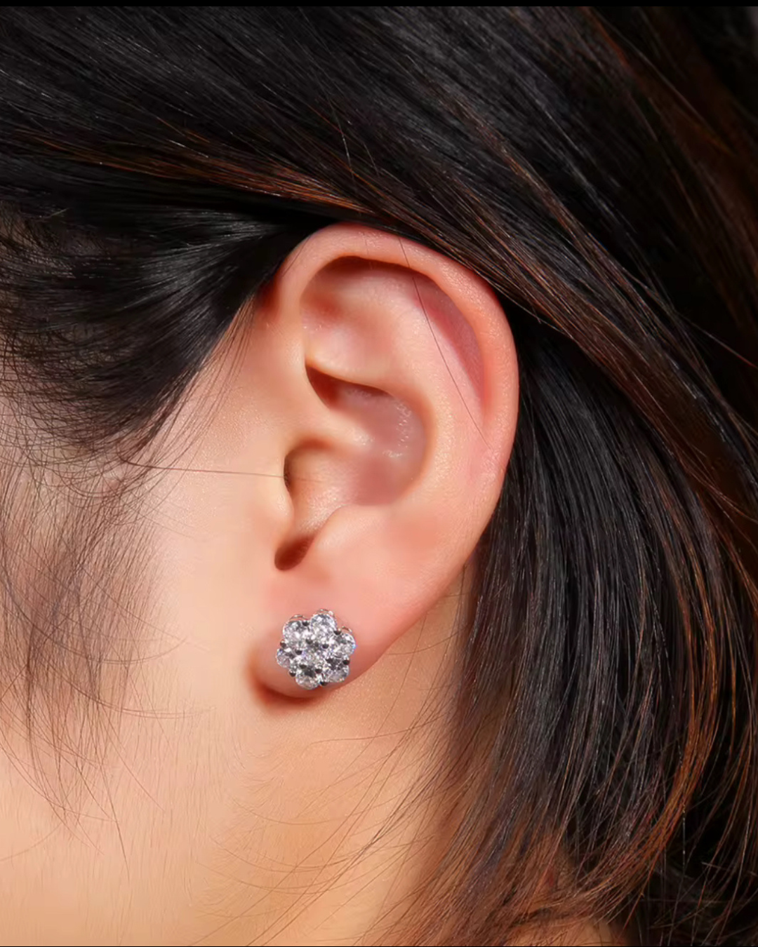 Silver flower cluster stud earrings with CZ stones, worn on ear for everyday sparkle.