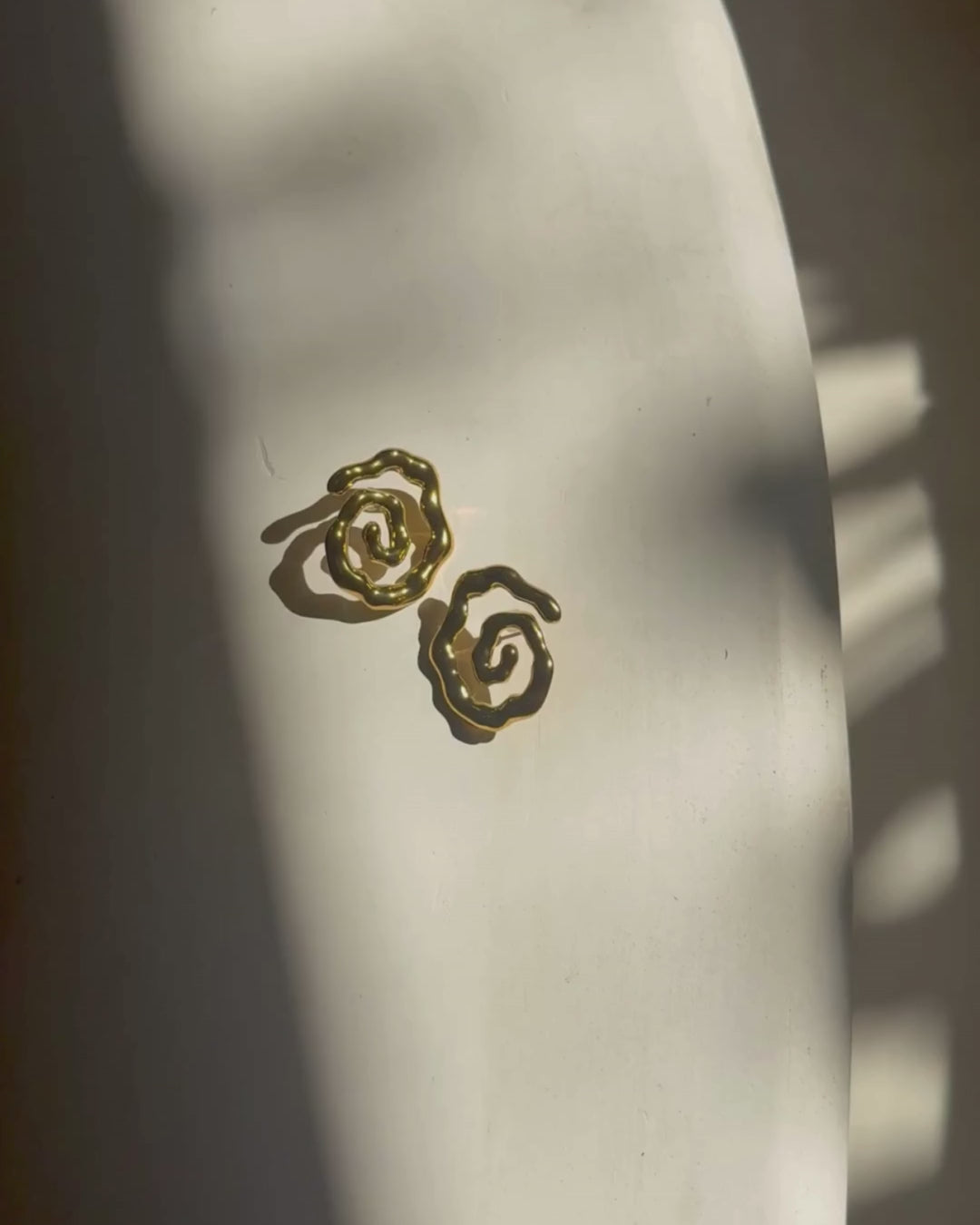 Close-up video zoom on Twist of Faith Earrings in gold, highlighting their sculptural spiral design — perfect for vacation outfits, beach getaways, and resort style looks.