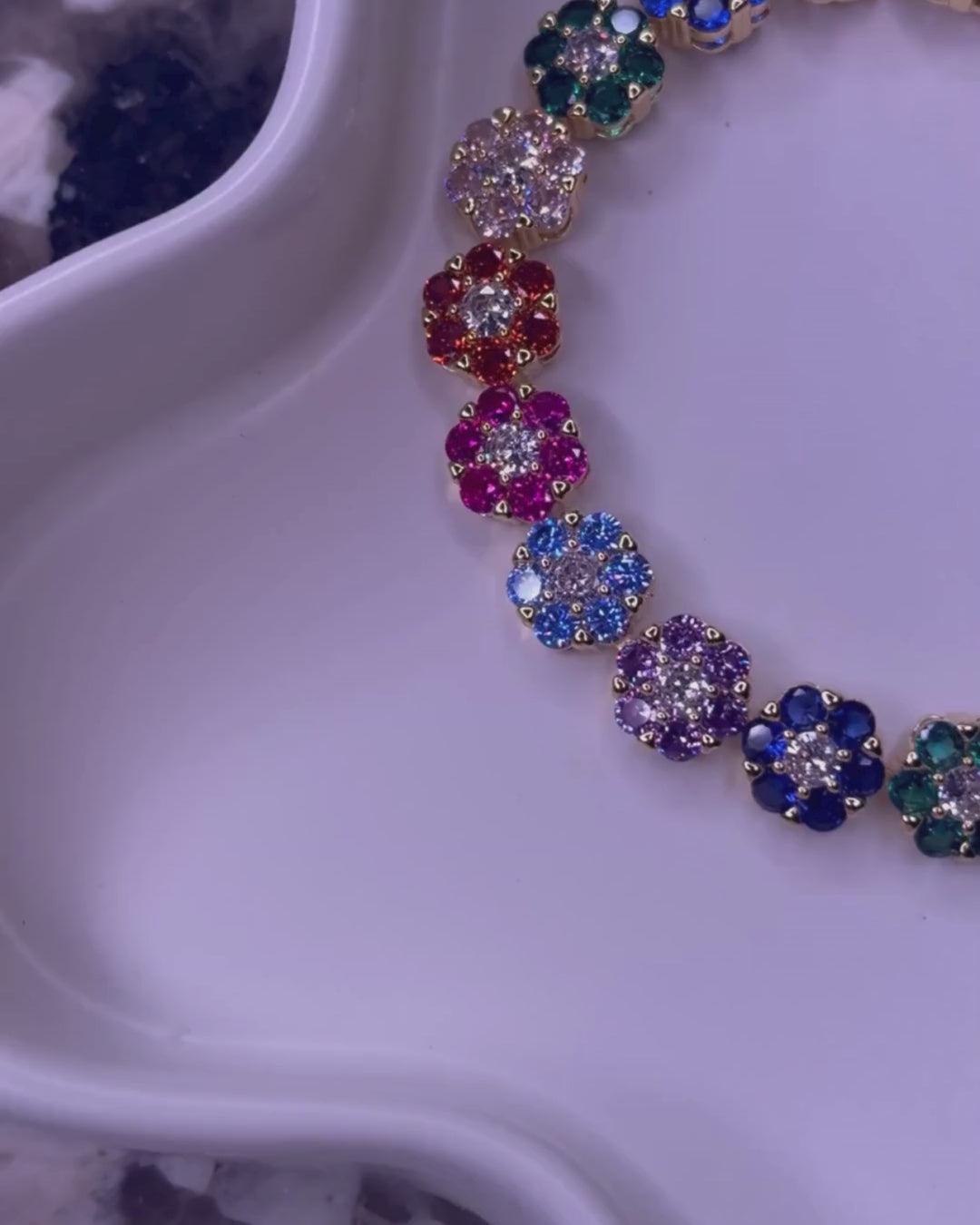 Video of the In Full Bloom Bracelet and matching necklace – multicolor CZ floral cluster jewelry in 18k gold and silver stainless steel, shown on a white tray with a marble background, as the camera pans in a circle for a full view.